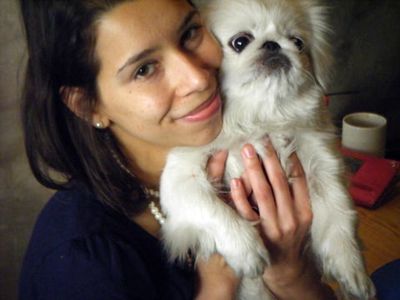 Woman holding Pekingese dog close to her face