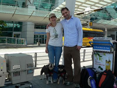 Two people stand with dogs and crates outside Incheon Airport
